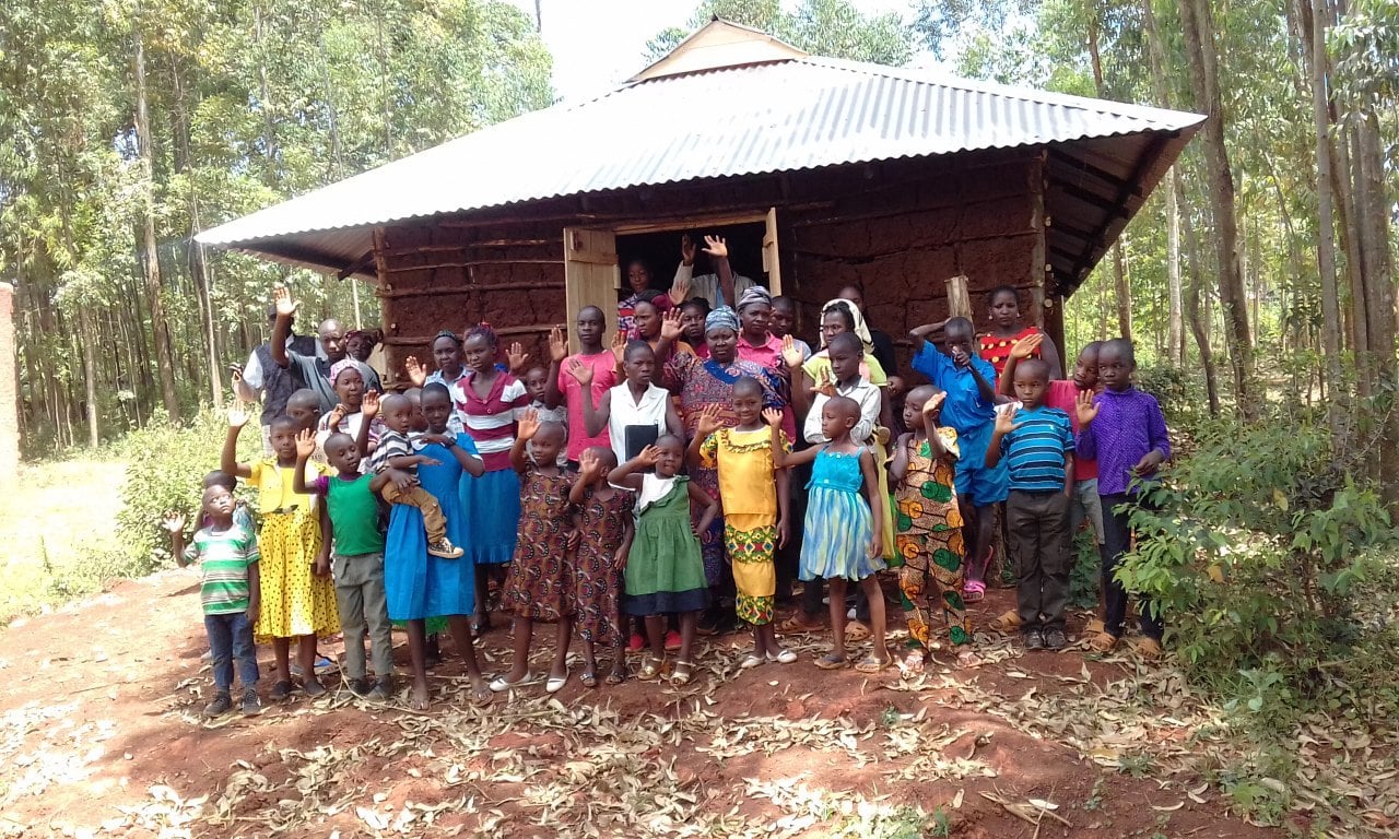 Children waving at the village church, 2018.