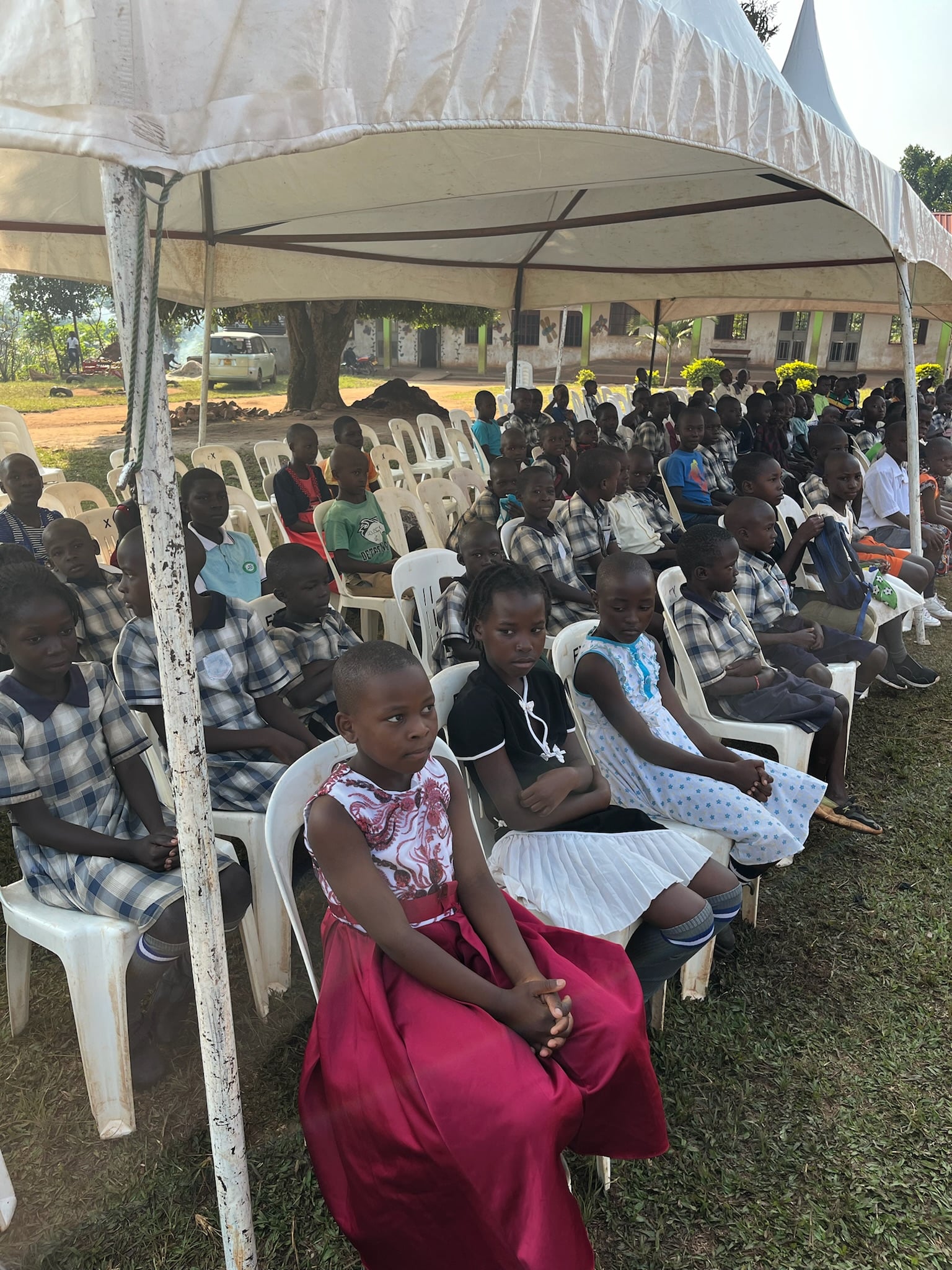 Children seated under tents at Grace, 2024.
